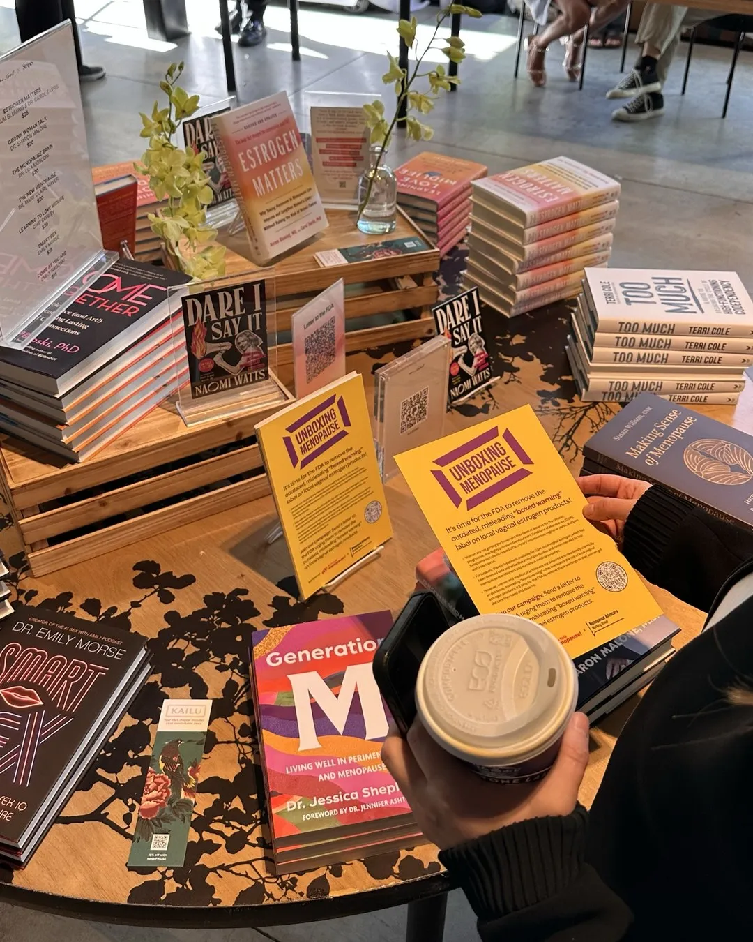 A market-style table stacked with books and leaflets at an event