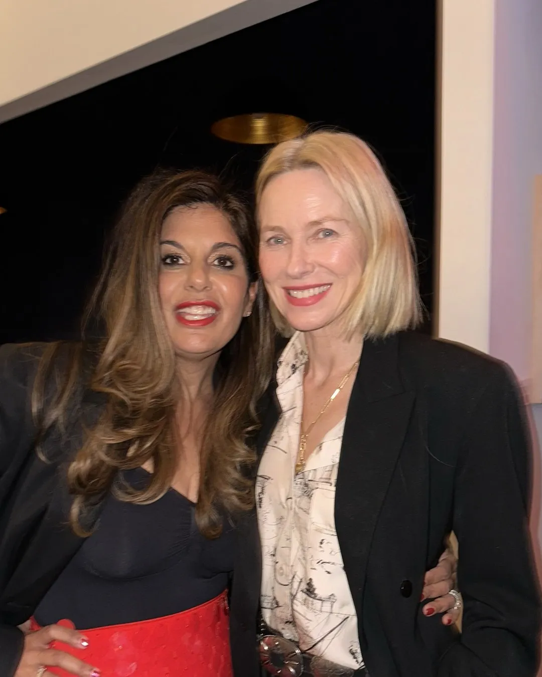 Two women smiling and posing close together at an event